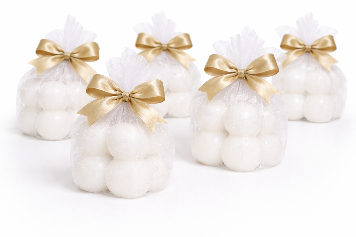 Weiße Kerze als Geschenk verpackt mit goldener Schleife, kleines fertiges Geschenk für Geburtstag oder besondere Anlässe