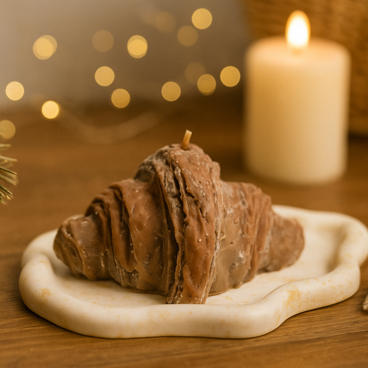 Croissant Kerze als dekorative Dessert Kerze in gemütlicher Wohnzimmer Atmosphäre, warme Geschenkidee für Herbst und Winter